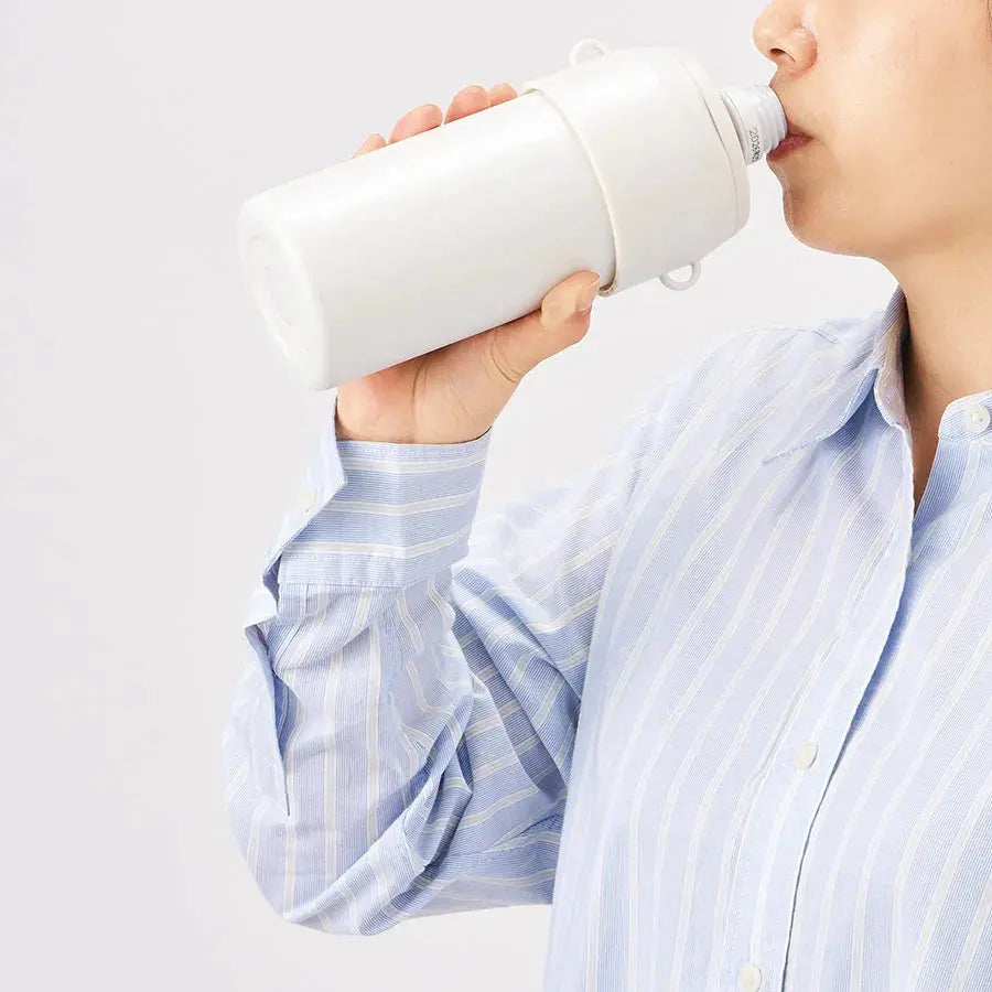 白い水筒で水分補給をする人、キッチン用品、シンプルデザイン
